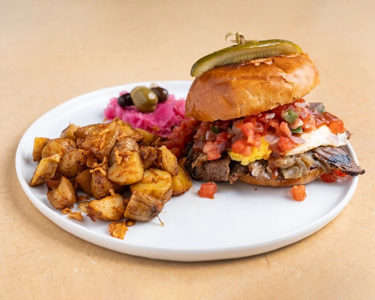 Le Brisket Burger — Pain brioche, Oeuf, Brisket, oignons caramélisés, sauce BBQ, Pico de Gallo.