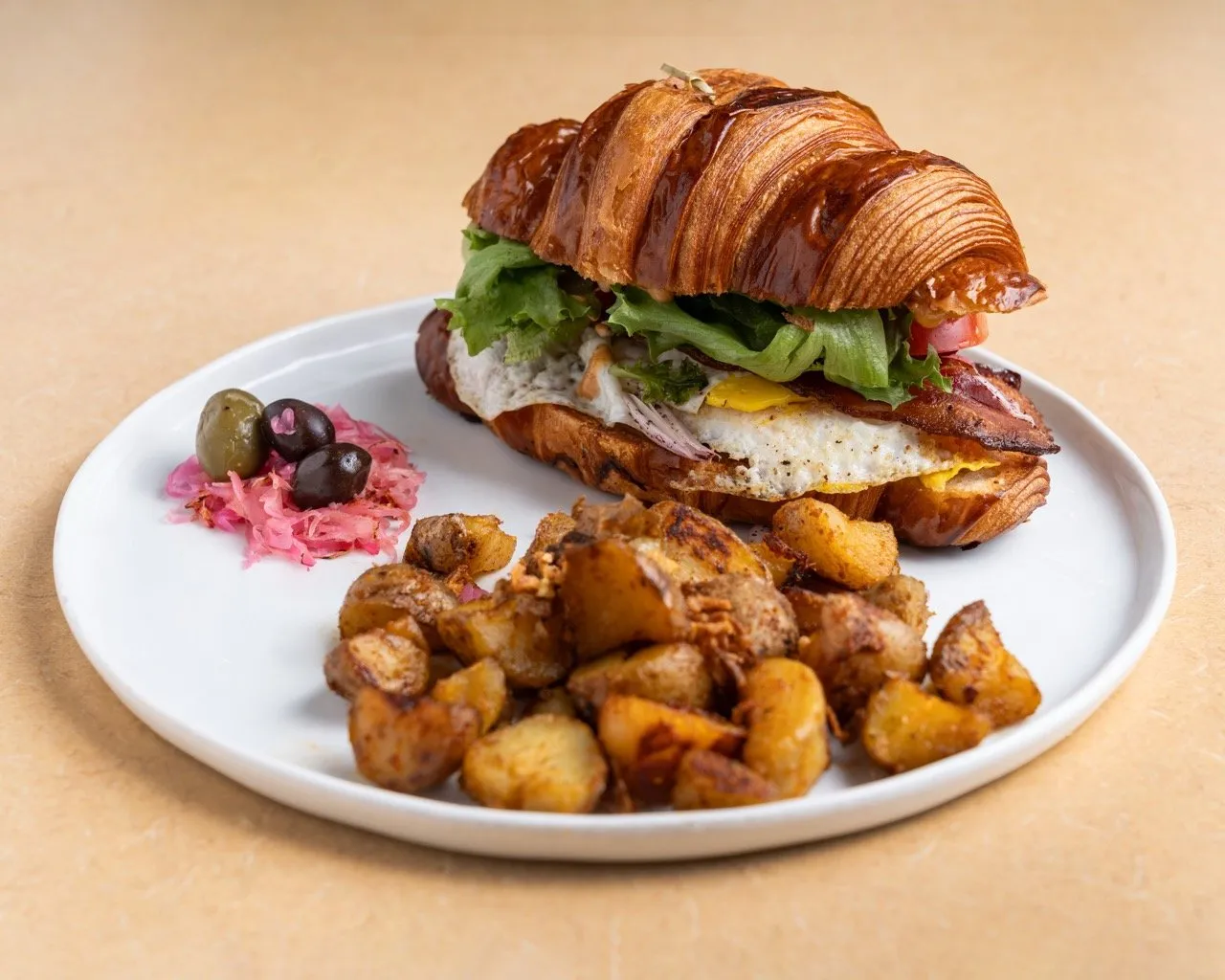 Le Croissant — Croissant, Oeuf, Avocat, Bacon, Mayo, Laitue, Tomates, Oignons.